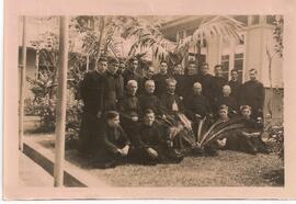 Grupo de sacerdotes y seminaristas posando en una zona verde