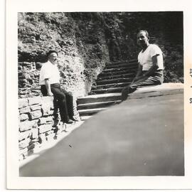 Dos hombres sentados en un muro de piedra