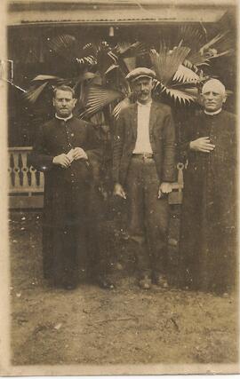 Hombre con boina y dos sacerdotes