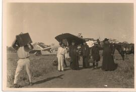 Grupo de sacerdotes frente a un avión
